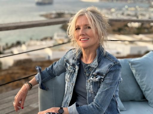 2025 Mature lifestyle model seated outdoors wearing denim jacket by waterfront